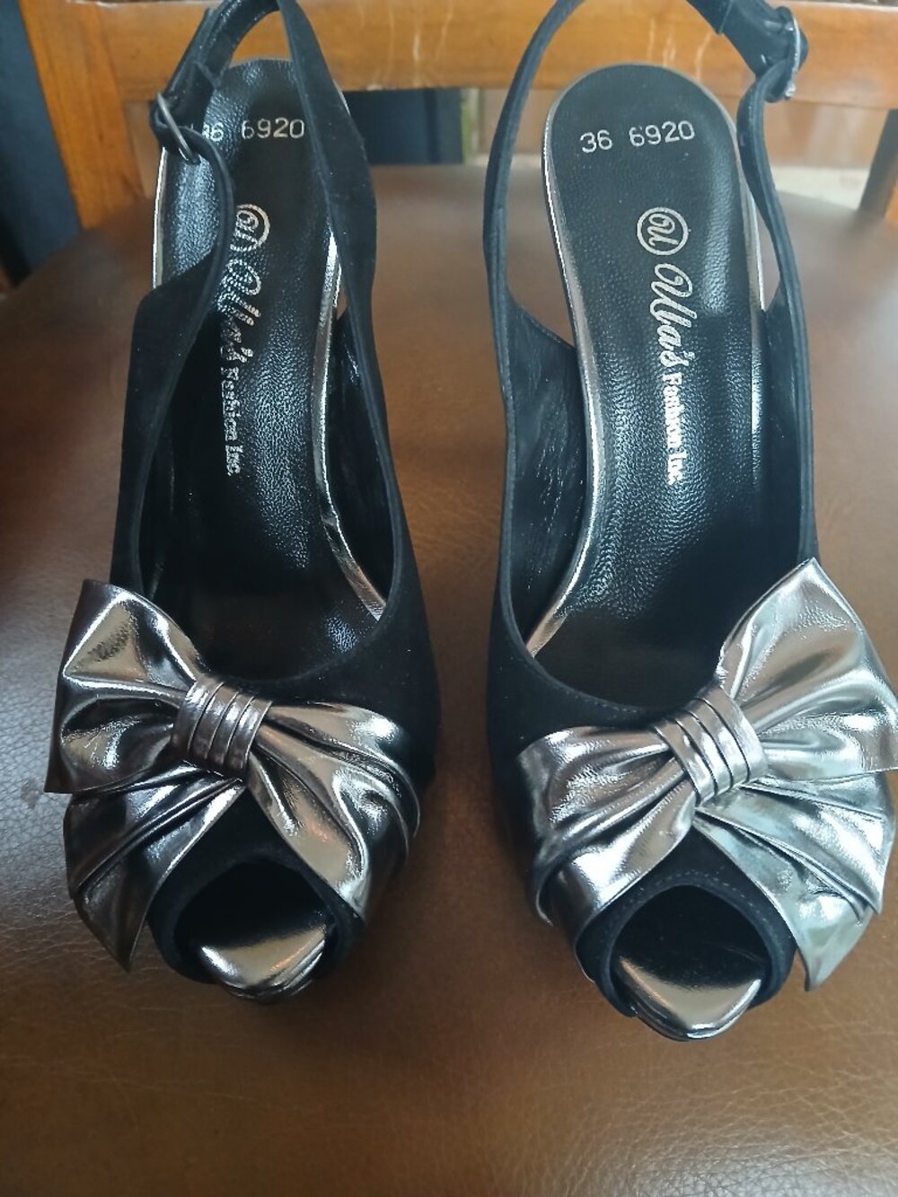 Black brushed leather pumps with a silver chignon.